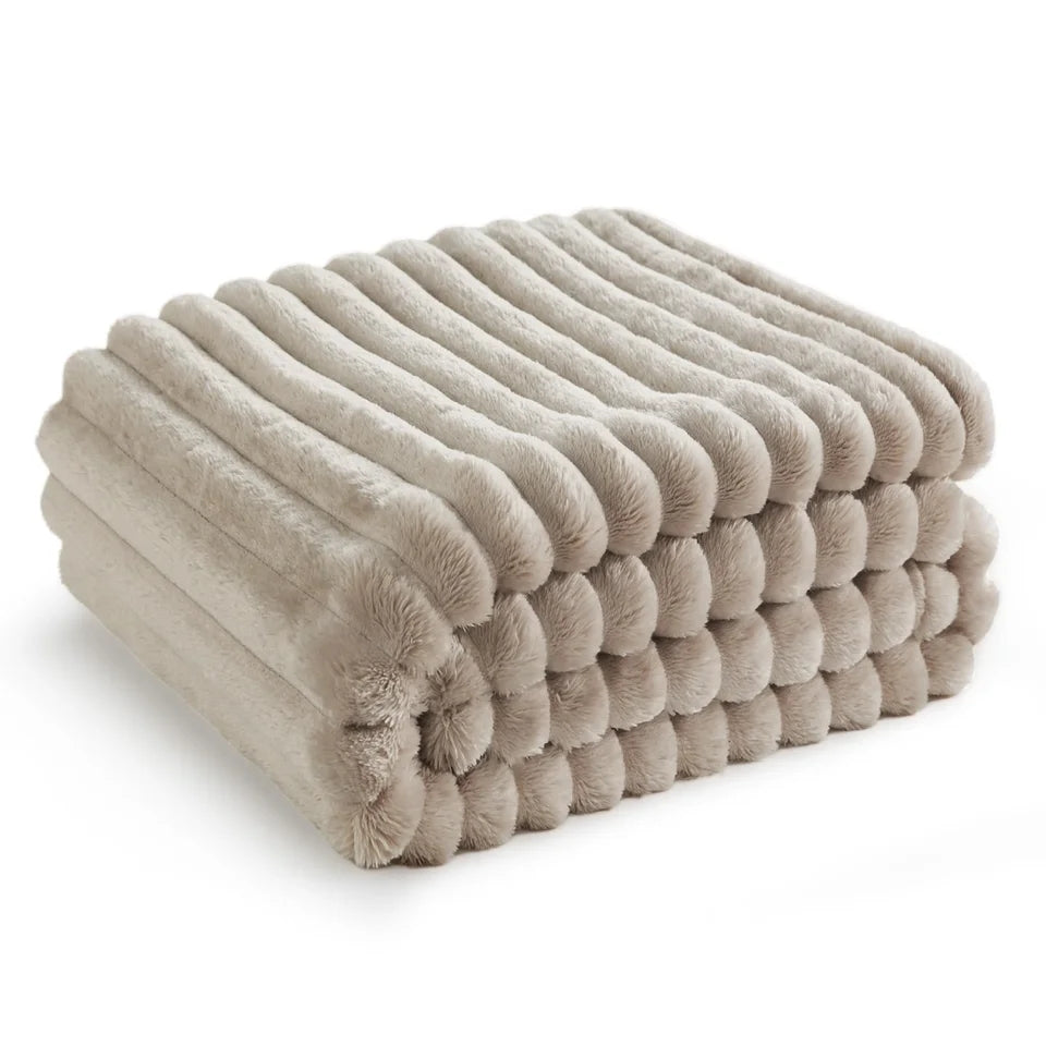 Een stapel netjes opgevouwen beige handdoeken gemaakt van comfortabel pluche materiaal, met een gestructureerd ontwerp op een witte achtergrond van Act Design Shop's Comfort Deken 150x200cm.